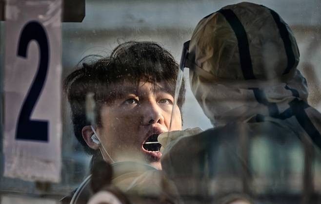 21일 중국 상하이 기차역에서 한 시민이 코로나 검사를 받고 있다. /EPA 연합뉴스