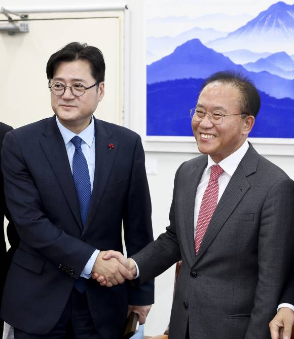 윤재옥 국민의힘 당 대표 권한대행 겸 원내대표와 홍익표 더불어민주당 원내대표가 12월20일 서울 여의도 국회 운영위원장실에서 2024년도 예산안 합의를 마친 뒤 악수하고 있다. ⓒ 연합뉴스