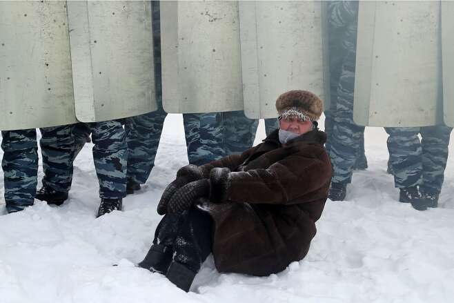 24일 러시아 예카테린부르크에서 열린 시위에서 한 참가자가 경찰바리케이트 앞 눈밭에 앉아있다./TASS 연합뉴스