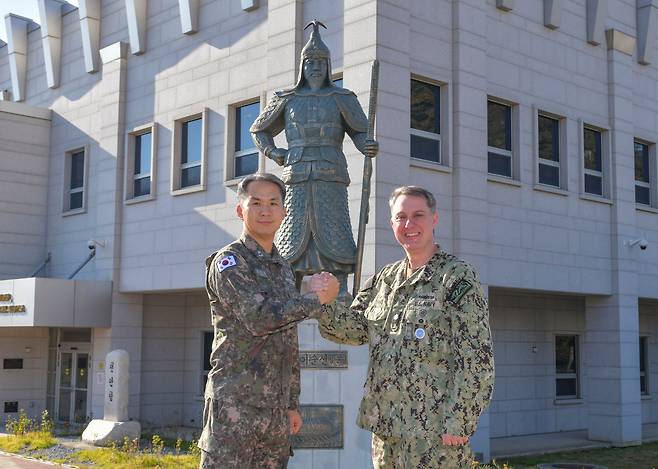 김지훈(왼쪽) 해군본부 정보작전참모부장과 마이크 바스 주한 미 해군사령부 참모장이 부산 남구 주한 미 해군사 본부 건물 앞에 있는 ‘충무공 이순신 장군’ 동상 앞에서 손을 맞잡고 있다. 이순신 장군상은 1985년 미군이 주문·제작한 것으로 미 항공모함 등 전략 자산이 부산을 찾을 때마다 미군 함장과 수병들이 이곳을 ‘순례지’처럼 찾는다고 한다. /노석조 기자