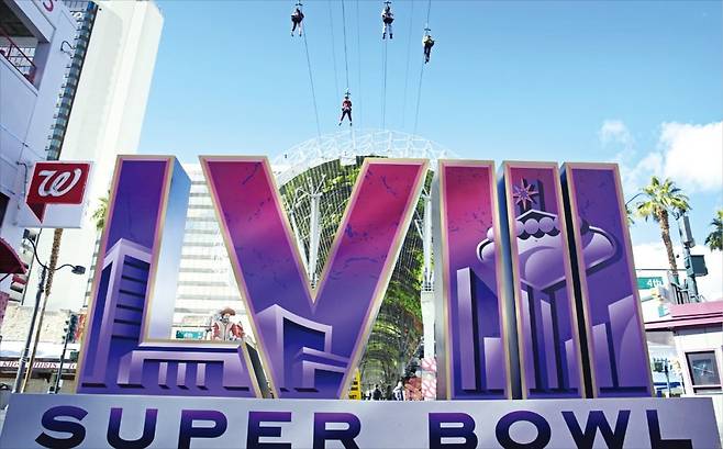 지난 2일 미국 네바다주 라스베이거스에 세워진 대형 ‘슈퍼볼’ 조형물 위로 사람들이 집라인을 타고 있다. 미국프로풋볼리그(NFL) 결승전인 슈퍼볼은 오는 11일부터 라스베이거스 얼리전트스타디움에서 열린다. /AP연합뉴스