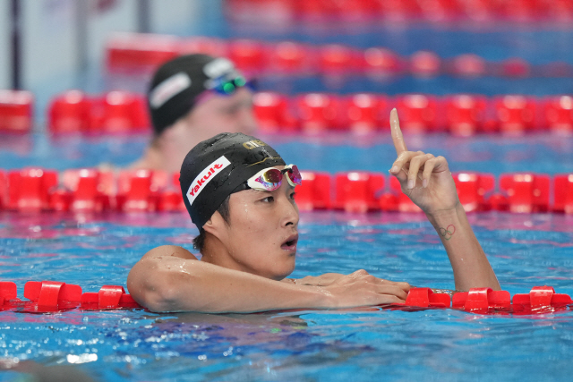 ▲ 김우민이 12일(한국시간) 카타르 도하 어스파이어돔에서 열린 2024 세계수영선수권 경영 남자 자유형 400ｍ 결승을 마친 뒤, 기록과 순위를 확인하고 있다. 이날 김우민은 3분42초71로 우승했다.  연합뉴스