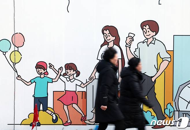 (서울=뉴스1) 박정호 기자 = 신생아 특례대출 신청이 시작된 29일 서울 도심의 공사장 가림막에 그려진 행복한 가족 그림 앞으로 시민들이 지나고 있다. 정부의 저출산 극복을 위한 주거 안정 방안에 따라 시행되는 신생아 특례대출은 대출신청일 기준 2년 내 출산·입양한 무주택 가구나 1주택 가구(대환대출)에 대해 주택구입이나 전세자금을 저금리에 대출해 주는 제도로 올해 대상은 2023년 1월1일 이후 출생아를 둔 출산 가구(입양가구)이며, 구입 자금 금리는 1.6~3.3%, 전세자금은 1.1~3.0%가 적용된다. 특례대출은 일반 디딤돌·버팀목 상품과 동일하게 주택기금 대출 취급 은행(우리·국민·농협·신한·하나은행 5개) 및 기금e든든 홈페이지를 통해 신청할 수 있다. 2024.1.29/뉴스1 Copyright (C) 뉴스1. All rights reserved. 무단 전재 및 재배포, AI학습 이용 금지.