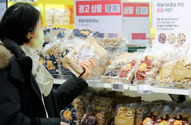 기상 악화에 따른 생산량 감소 여파에 오곡밥과 부럼 가격이 대부분 올랐다. 서울 이마트 용산점에서 고객이 땅콩과 호두 등의 부럼 세트를 고르고 있다. /사진=뉴시스