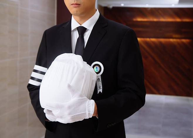 한 상주(喪主)가 고인의 유골함을 가슴에 품고 있다. 가장 평온해야 할 이 순간에 각종 잡음이 끊이지 않는다. /게티이미지뱅크