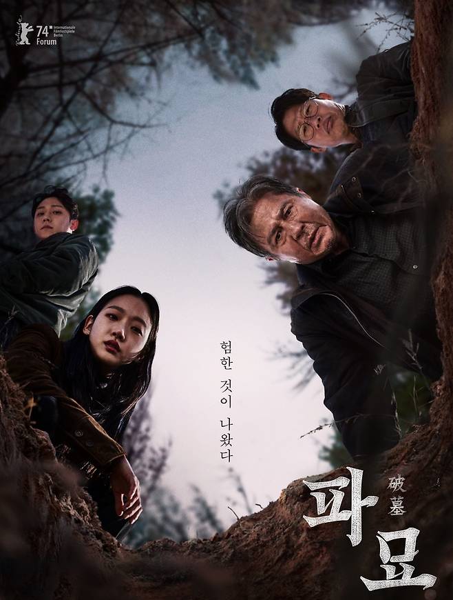 영화 ‘파묘’에서 주인공들이 무덤 속을 들여다보는 장면. 왼쪽부터 법사 봉길(이도현), 무당 화림(김고은), 풍수사 상덕(최민식), 장의사 영근(유해진). 하늘이 한반도 모양이다. /쇼박스