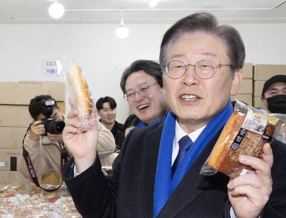 23일 방송된 SNL코리아 시즌5의 ‘맑눈광이 간다’ 코너에서 추미애 전 장관에게 보여준 사진. 이재명 더불어민주당 대표가 지난 5일 오후 서울 영등포 뉴타운 지하쇼핑몰을 찾아 빵을 구매하고 있다. 뉴스1