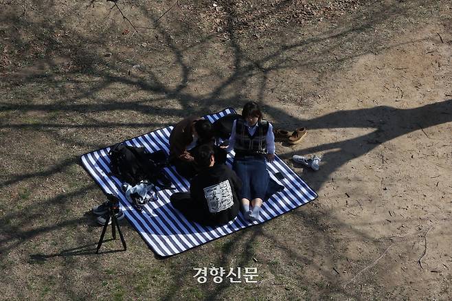 포근한 봄 날씨가 이어진 24일 서울 여의도한강공원을 찾은 시민들이 그늘 아래에 돗자리를 펴놓고 담소를 나누고 있다.