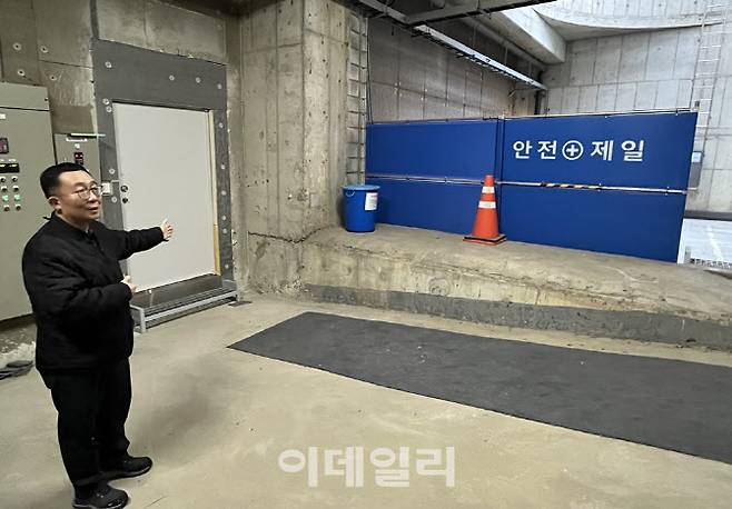 아모레퍼시픽 시설관리 협력사인 대경이앤에스 신유정 과장이 조형물 기계실을 소개하고 있다. 뒤에 보이는 하얀 문이 건물 내부와 연결되는 통로다.(사진=서대웅 기자)