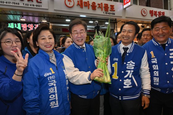 이재명 더불어민주당 대표가 지난 24일 서울 송파구 잠실 새마을전통시장을 방문해 파를 들고 있다. 뉴스1