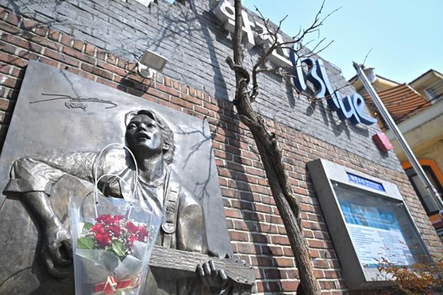 지난 15일 서울 종로구 대학로 소극장 학전블루 김광석 추모비 앞에 시민들이 두고 간 꽃이 놓여 있다. 학전 현판은 31일 철거된다. 정다빈 기자