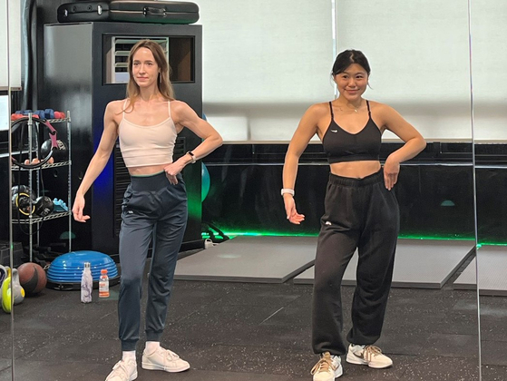 Mary, right, practices posing like a bodybuilder. [MARY YANG]