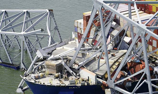 27일(현지시각) 미 메릴랜드주 볼티모어항 입구의 프랜시스 스콧 키 브리지를 무너트린 대형 화물선 '달리'가 다리 구조물에 걸려 있다. AP뉴시스