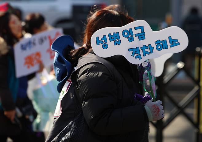 지난 8일 서울 종로구에서 열린 ‘민주노총 세계여성의날 정신 계승 전국노동자대회’에 참석한 시민이 손팻말을 들고 행진하고 있다. 연합뉴스