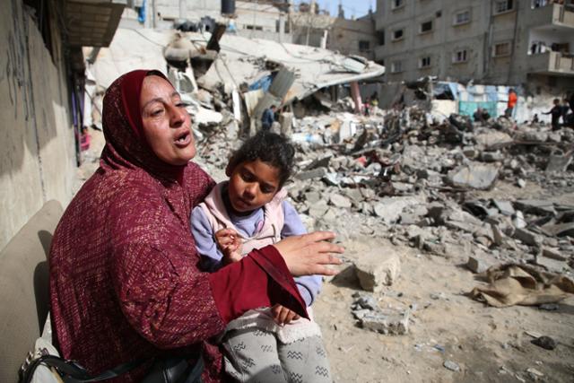 유엔 안전보장이사회(안보리)가 이스라엘과 하마스에 즉각적 휴전을 촉구하는 결의안을 채택하고 이틀이 지난 27일 가자지구 최남단 도시 라파에서 한 여성이 이스라엘군의 공습으로 파괴된 건물 잔해 근처에 앉아 있다. 라파=신화 뉴시스