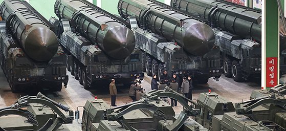 김정은 북한 국무위원장이 대륙간탄도미사일 이동식 발사대를 생산하는 ‘중요군용대차생산공장’을 방문해 관계자들과 대화하고 있다. ‘비밀엄수’ 표어가 눈길을 끈다. 연합뉴스