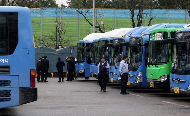 서울 시내버스 총파업이 시작된 28일 서울의 한 공영 차고지에 주차된 버스들 사이로 기사들이 모여 이야기를 나누고 있다. [연합]
