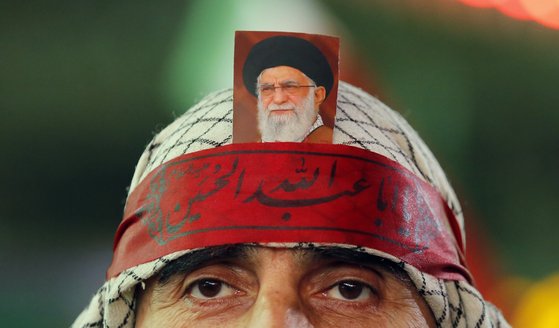 1일(현지시간) 이란 테헤란 팔레스타인 광장에서 열린 반이스라엘 시위 도중 한 남성이 이란 최고 지도자 알리 하메네이의 사진을 이마에 올려놓고 있다. EPA=연합뉴스