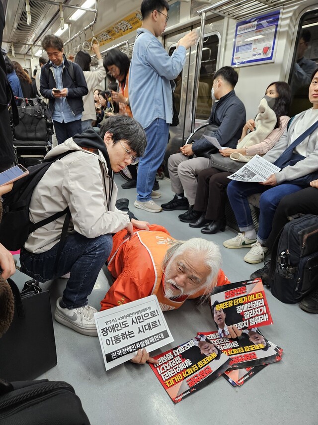3일 오전 8시21분 서울 지하철 5호선 열차 안에서 박경석 전국장애인차별철폐연대 상임공동대표가 시민들에 장애인 권리를 위한 투표를 호소하며 ‘포체투지’를 하고 있다. 김채운 기자