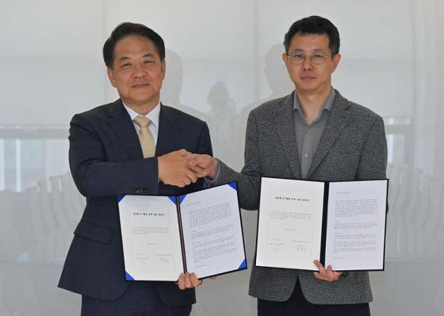 한국일보사 이성철 사장(왼쪽)과 유환구 노조위원장이 4일 서울 중구 세종로 한국일보 본사에서 '생성형 AI 활용 준칙' 조인식을 갖고 악수하고 있다. 정다빈 기자