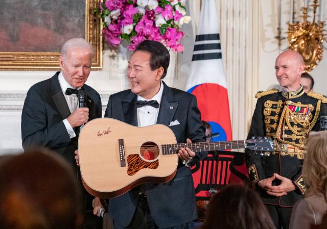 ▲미국을 국빈 방문한 윤석열 대통령이 백악관에서 열린 국빈만찬 특별공연에서 조 바이든 대통령으로부터 미국 싱어송라이터 돈 매클린의 친필 서명이 담긴 기타를 선물받고 있다. ⓒ연합뉴스