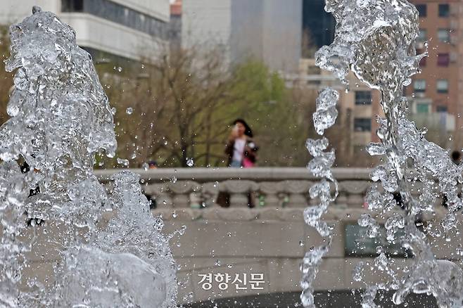 따뜻한 날씨가 이어진 8일 서울 중구 청계광장 일대에서 한 외국인 관광객이 시원하게 뿜어지는 분수를 사진으로 담고 있다.