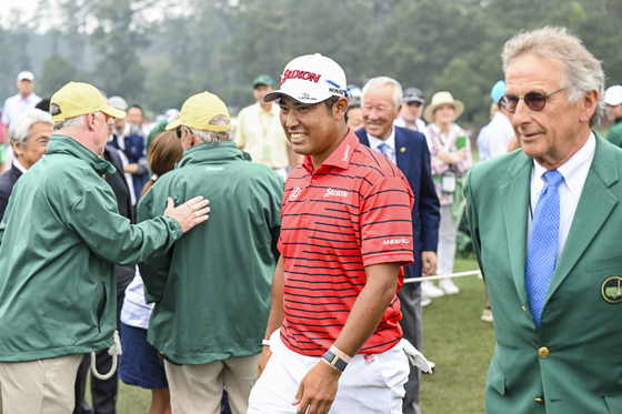 Hideki Matsuyama of Japan smiles after greeting former Japanese golfer Isao Aoki during practice for the Masters Tournament at Augusta National Golf Club in Augusta, Georgia on April 4, 2023.  [GETTY IMAGES]