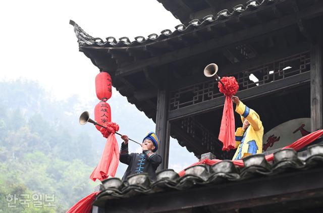 장강삼협 크루즈 중 투자족 주민 공연단이 삼협인가 투어에서 환영 나팔을 불고 있다.