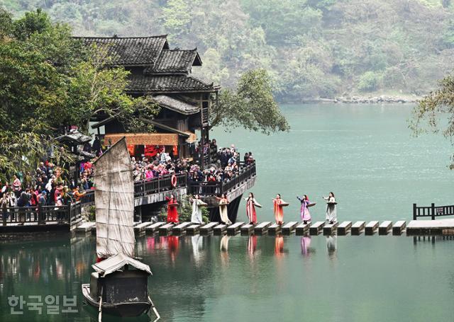 장강삼협 크루즈 삼협인가 투어에서 전통복장을 입은 투자족 여인들이 환영의 춤을 추고 있다.