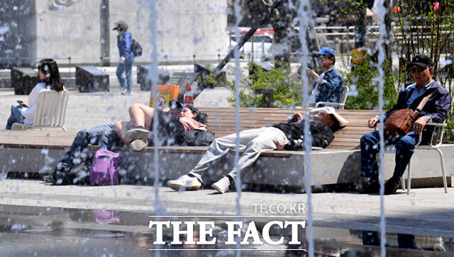 '휴양지 못지 않네~' 시민들이 바닥분수 앞에 누워 휴식을 취하고 있다.