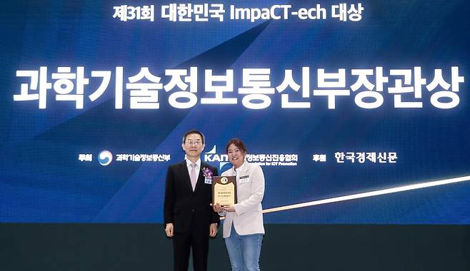 SK텔레콤이 17일 월드 IT쇼에서 개최된 '대한민국 임팩테크 대상'에서 'AI 미디어 스튜디오'로 과학기술정보통신부 장관상을 수상했다. 임정연 SKT 미디어 R&D 담당(사진 오른쪽)이 이종호 과기부 장관으로부터 상을 받았다. (SK텔레콤 제공)