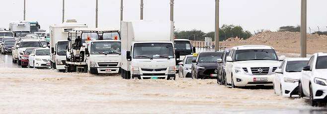 차량들이 16일(현지시각) 물에 잠긴 아랍에미리트 두바이 거리를 조심스럽게 지나고 있다. EPA 연합뉴스