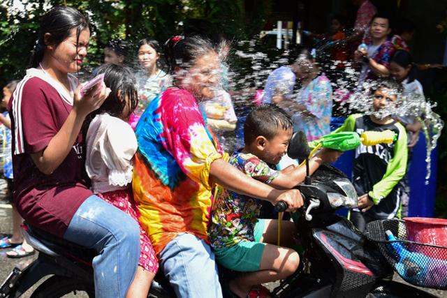 태국 송크란 기간인 지난 13일 남부 도시 나라티왓에서 시민들이 달리는 오토바이를 향해 물을 뿌리고 있다. 나라티왓=AP 연합뉴스
