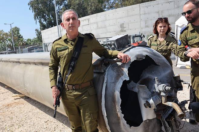 이스라엘군 수석 대변인 다니엘 하가리 소장(왼쪽)이 16일 이스라엘 남부 키랴트 말라치 인근 줄리스 군사 기지에서 이스라엘이 요격해 떨어뜨린 이란 탄도 미사일을 보여주고 있다. /AFP 연합뉴스