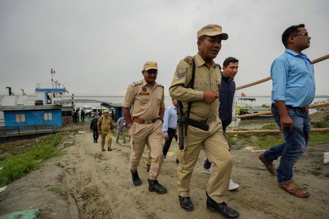 18일 인도 동북부 아삼주 니마티 가트에서 선관위 관계자들과 경비원들이 배로 싣고 온 전자투표기를 들고 격오지 투표소로 향하고 있다. 니마티 가트=AP 뉴시스