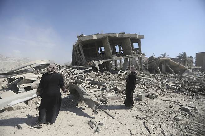 이스라엘 지상군이 철수한 팔레스타인 가자지구 칸유니스에서 7일(현지시간) 주민들이 폐허가 된 건물 잔해를 살펴보고 있다.  AP연합뉴스