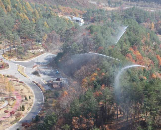 지난해 11월 수도권의 한 사찰 주변에 25m 높이로 설치된 특수소화시설(수막타워)에서 산불 위험 대비 예방살수를 하고 있다.  산림청 제공