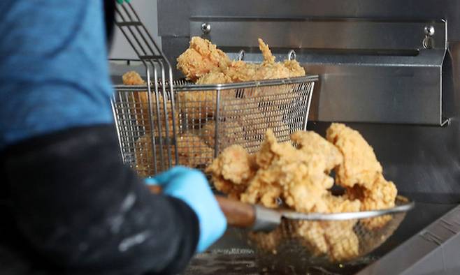 서울 시내 한 치킨 가맹점에서 점주가 치킨을 튀기고 있다. 뉴시스