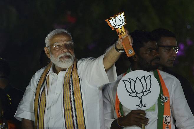 [첸나이=AP/뉴시스] 나렌드라 모디 인도 총리가 9일(현지시각) 인도 첸나이에서 열린 선거 운동 중 본인이 이끄는 '인도국민당'(BJP)을 상징하는 연꽃 조형물을 들고 지지자들에게 인사하고 있다. 인도 총선이 오는 19일부터 6월4일까지 6주 동안 펼쳐진다. 2024.04.10.
