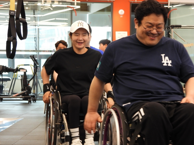 '썬데이 크루' 팀원들이 운동 시작 전 휠체어로 센터를 돌며 몸을 풀고 있다.