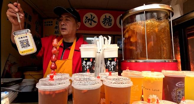 중국에선 작은 액수라도 간편결제를 사용한다. 사진은 알리페이로 결제를 요구하는 탕후루 가게 주인 모습.