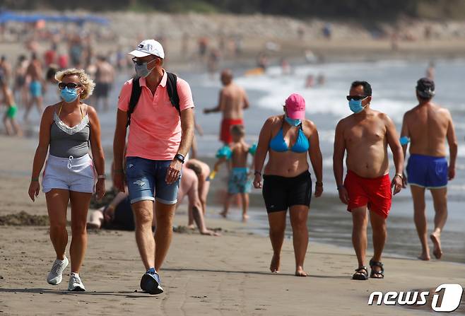 스페인령 카나리아 제도의 플라야 델 잉글레스에 위치한 해변에서 여행객들이 산책하고 있다. 2020.12.1 ⓒ 로이터=뉴스1 ⓒ News1 강민경 기자