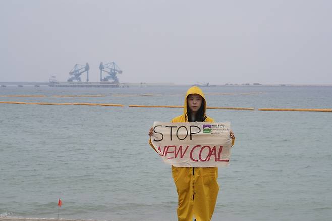 환경운동연합 활동가가 20일 삼척블루파워 규탄 피켓을 들고 맹방해변에 서있다. 기후연대기구 제공