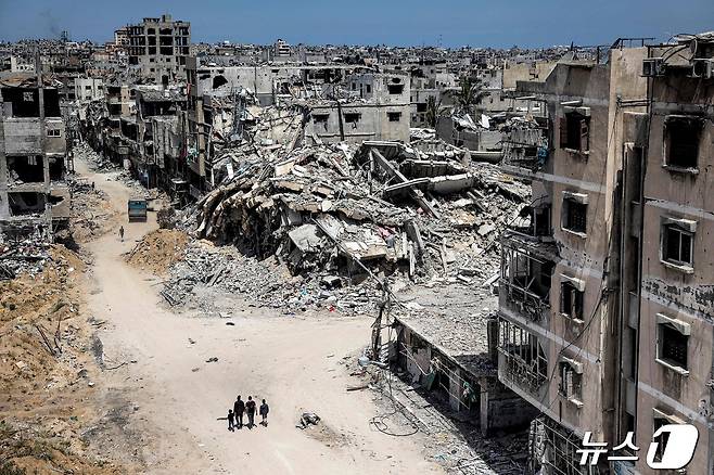 22일 팔레스타인 남부 칸유니스 지역을 사람들이 걸어가고 있다. 6개월 이상 지속된 가자 전쟁으로 도시 건물들이 처참하게 훼손됐다. 2024.04.22 ⓒ AFP=뉴스1 ⓒ News1 최종일 기자