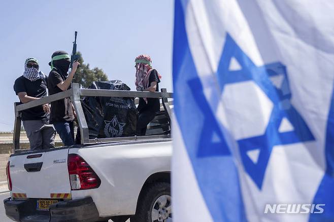 [예루살렘=AP/뉴시스] 하마스 무장세력의 복장을 한 이스라엘 시위대가 3일(현지시각) 예루살렘에 있는 유엔 팔레스타인 난민구호기구(UNRWA) 본부 입구에서 시위하고 있다. 2024.04.04.