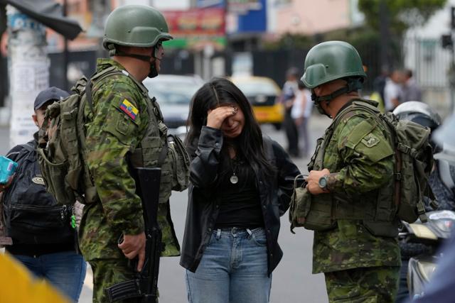 4월 18일 에콰도르 수도 키토에서 한 여성이 순찰 중이던 군인들에게 울면서 강도 사건을 신고하고 있다. 키토=AP 뉴시스