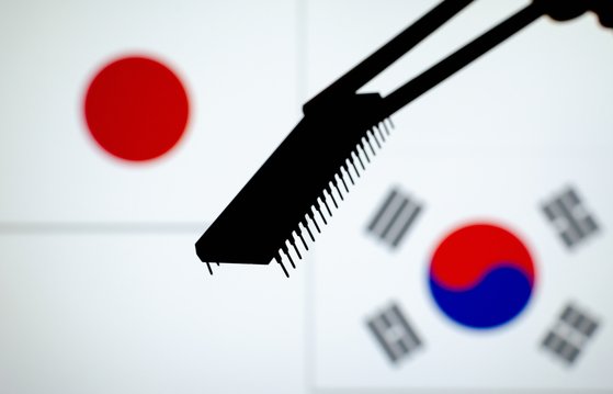 반도체 칩 뒤로 한국과 일본의 국기가 맞닿아 있다. 셔터스톡