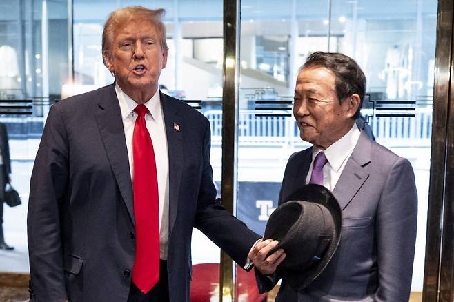 도널드 트럼프 전 미국 대통령(왼쪽)이 23일 뉴욕 트럼프타워 입구로 직접 나와 아소 다로 전 일본 총리를 맞이하고 있다. 아소 전
 총리는 트럼프 전 대통령과 친분이 두터웠던 아베 신조 전 일본 총리 재임 시절 부총리 겸 재무상을 지냈다. 뉴욕=AP 뉴시스