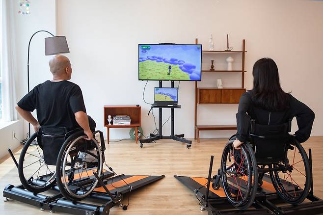 휠체어 이용자들이 휠체어를 탄 채 유산소 및 근력 운동을 할 수 있는 운동기구 ‘휠리엑스(Wheely-X)’를 이용하고 있다. 캥스터즈 제공