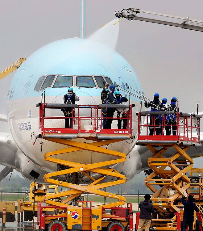 인천 중구 인천국제공항의 대한항공 주기장에서 25일 직원들이 장거리 투입 기종인 보잉 777-300 ER 항공기의 동체를 봄을 맞아 세척하고 있다.  한주형 기자